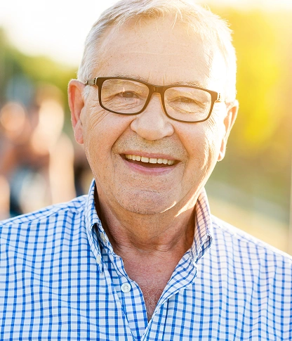 Senior patient smiling brightly after dental implants at willow street dental